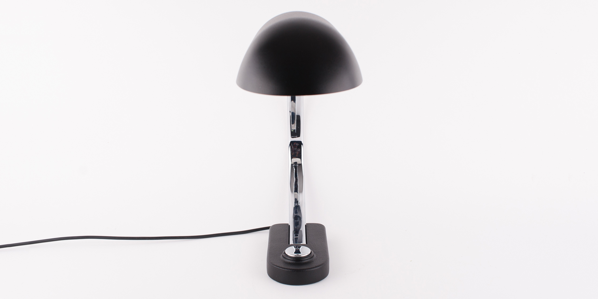 Diese Schreibtischlampe stammt aus der Manufaktur Hillebrand. Das Modell 7620 ist schwarz pulverbeschichtet und Chrom. Das Chrom als auch der schwarze Lack sind komplett neu beschichtet worden. Die Lampe ist in einem Topzustand. Durch ihren grossen Metallbügel hat die Lampe eine sehr elegante Form. Der Druckschalter ist ebenfalls aus Chrom. Der Schirm lässt sich mittels eines Inbusschlüssel verstellen. Der Schirm ist von innen weiss lackiert, sodass das Licht gut reflektieren kann. Höhe 40cm, B 14cm, Tiefe 65cm.