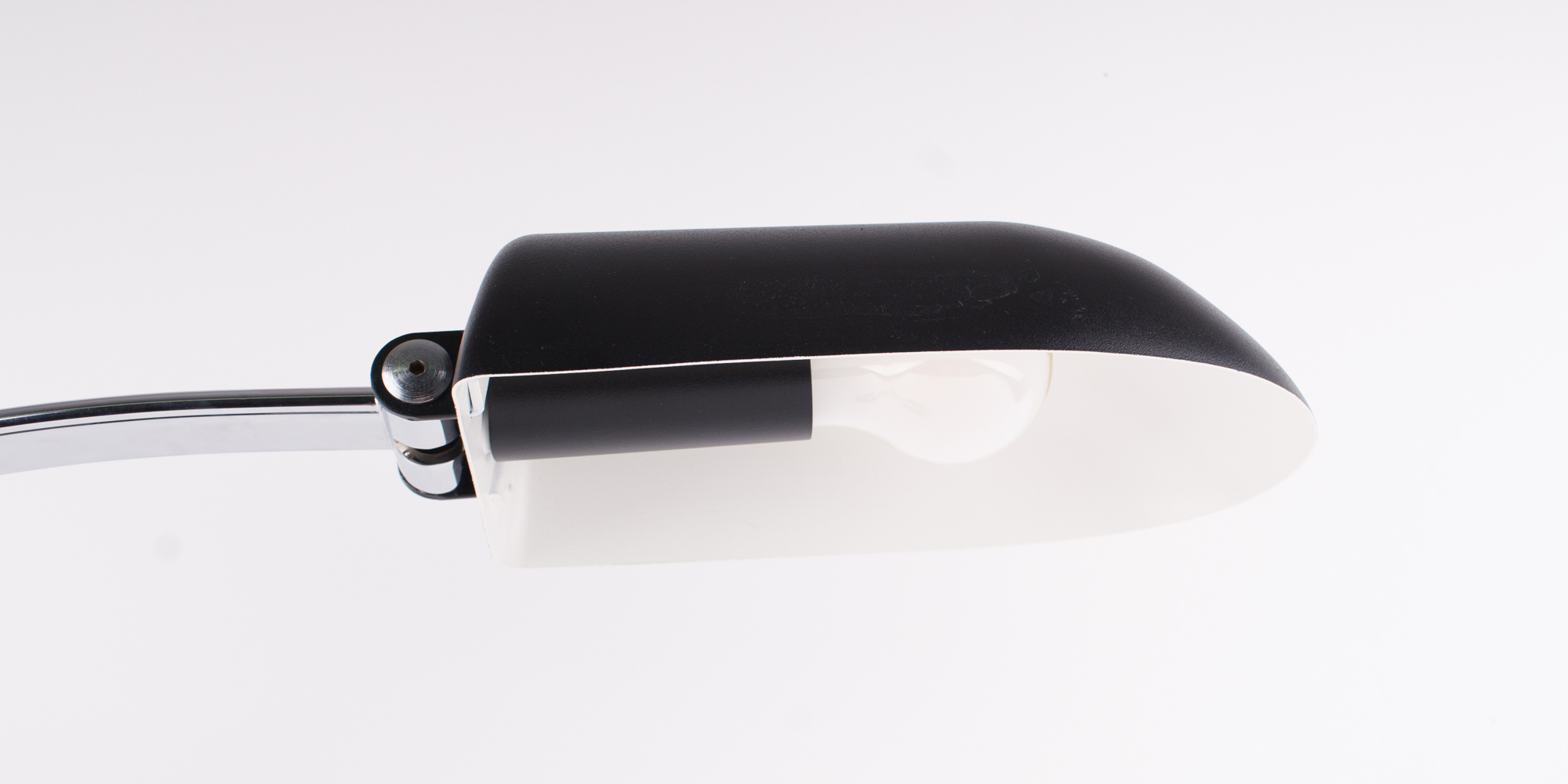 Diese Schreibtischlampe stammt aus der Manufaktur Hillebrand. Das Modell 7620 ist schwarz pulverbeschichtet und Chrom. Das Chrom als auch der schwarze Lack sind komplett neu beschichtet worden. Die Lampe ist in einem Topzustand. Durch ihren grossen Metallbügel hat die Lampe eine sehr elegante Form. Der Druckschalter ist ebenfalls aus Chrom. Der Schirm lässt sich mittels eines Inbusschlüssel verstellen. Der Schirm ist von innen weiss lackiert, sodass das Licht gut reflektieren kann. Höhe 40cm, B 14cm, Tiefe 65cm.
