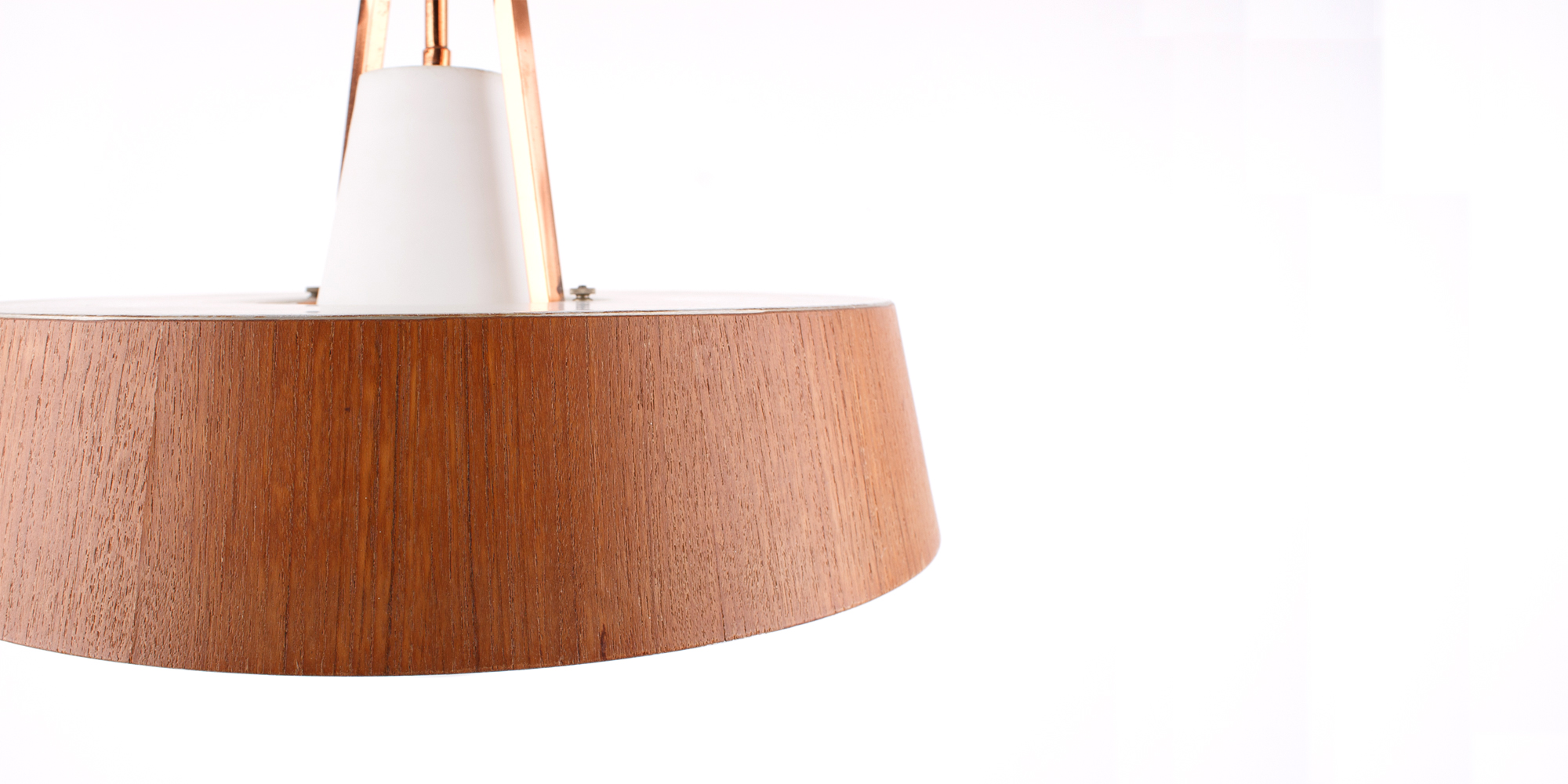 Eine Deckenlampe aus den 1960er Jahren. Das Gestell ist aus Kupfer mit einer Teakfurnierschicht und einem opakem, weissen Glaskorpus, der das Licht auf angenehme Art in den Raum streut. Die Lampe ist extravagant, lässt sich aber durchaus mit modernem Interieur kombinieren. Der Durchmesser der Lampe ist an der breitesten Stelle 40 cm und hat eine Höhe von 34 cm.