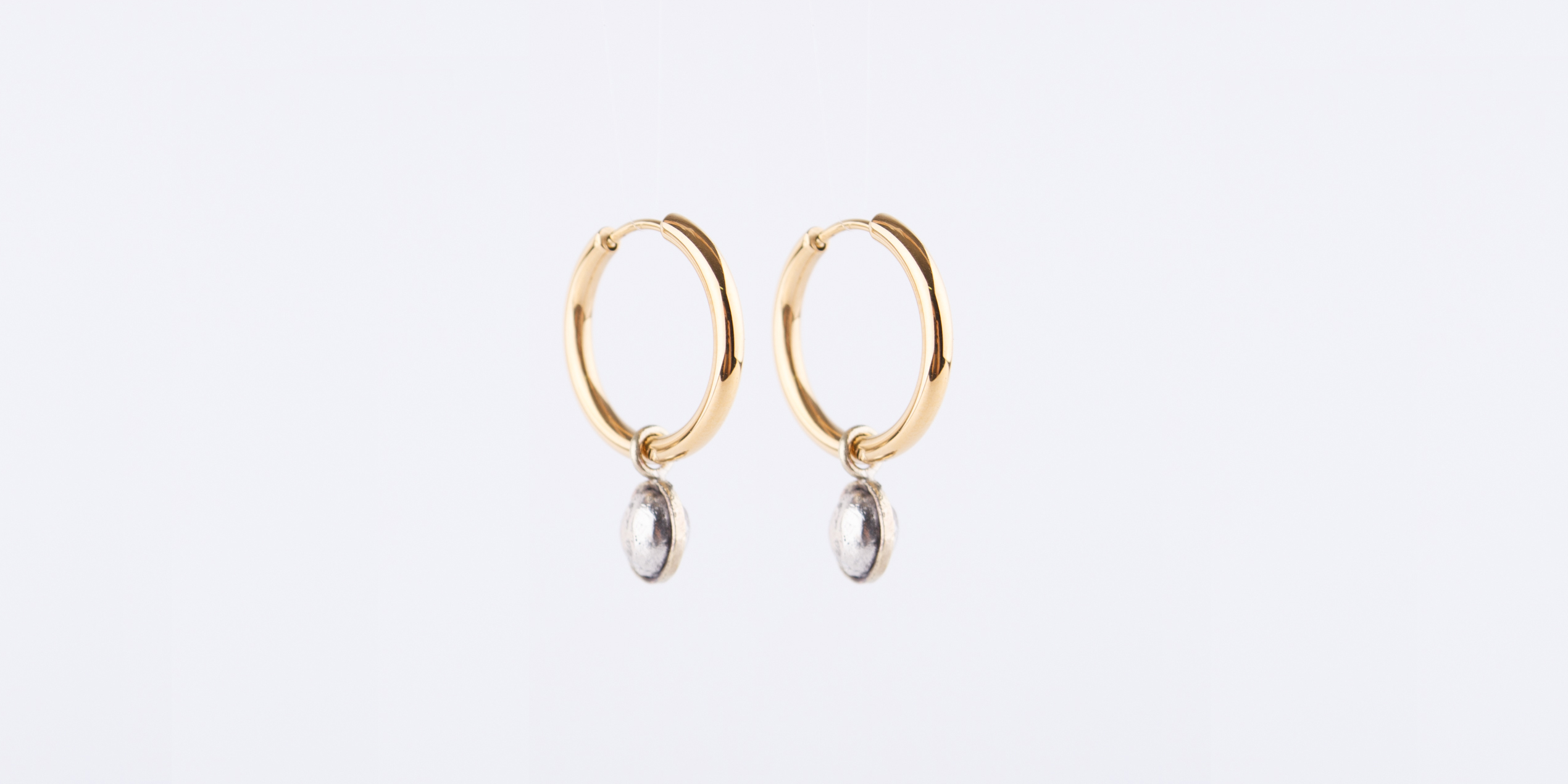 Die Creolen sind aus Edelstahl vergoldet. Die Charms sind handgeschmiedet und abnehmbar, sodass Du die Creolen auch pur tragen kannst. Die Charms kannst Du dann auch an der Kette tragen. Die Croelen kannst Du in 2,0 cm und in 1,3 cm bei mir kaufen.